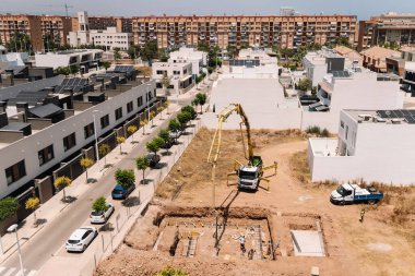 Valencia, İspanya - 20 Haziran 2025: Kentsel yerleşim alanına beton pompa kamyonu döken inşaat alanı, modern mimari ve geliştirme ilerlemelerini gözler önüne seriyor