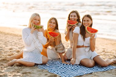 Dört güzel kadın karpuz yiyor ve piknikte günbatımının tadını çıkarıyor. Genç kız arkadaşlar birlikte vakit geçiriyorlar, sahilde eğleniyorlar. Rahatlama, dostluk, piknik anlayışı.