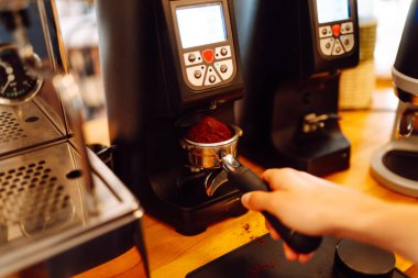 Önlüklü bir barmen barın arkasında kahve makinesiyle kahve hazırlar. Deneyimli bir barista sütünü köpürtür ve sıcak bir kafede taze espresso hazırlar. Tüketim konsepti, yemek servisi..