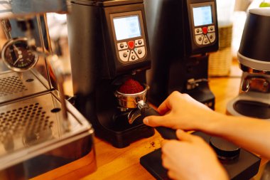 Önlüklü bir barmen barın arkasında kahve makinesiyle kahve hazırlar. Deneyimli bir barista sütünü köpürtür ve sıcak bir kafede taze espresso hazırlar. Tüketim konsepti, yemek servisi..