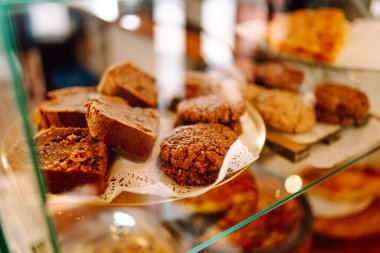 Taze ve lezzetli tatlılar bu sıcak fırının cam kubbesinin altında cezbedici. Kahve dükkanında mis kokulu tarçınlı çörekler, kekler ve kekler ile sıcak bir atmosfer. Tatlı ve yemek konsepti.