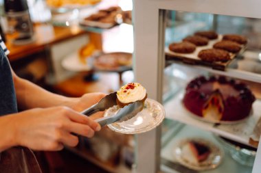 Taze ve lezzetli tatlılar bu sıcak fırının cam kubbesinin altında cezbedici. Kahve dükkanında mis kokulu tarçınlı çörekler, kekler ve kekler ile sıcak bir atmosfer. Tatlı ve yemek konsepti.