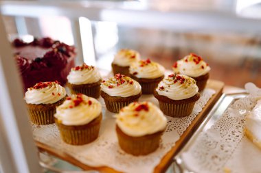 Taze ve lezzetli tatlılar bu sıcak fırının cam kubbesinin altında cezbedici. Kahve dükkanında mis kokulu tarçınlı çörekler, kekler ve kekler ile sıcak bir atmosfer. Tatlı ve yemek konsepti.