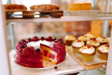 Taze ve lezzetli tatlılar bu sıcak fırının cam kubbesinin altında cezbedici. Kahve dükkanında mis kokulu tarçınlı çörekler, kekler ve kekler ile sıcak bir atmosfer. Tatlı ve yemek konsepti.