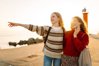 İki bayan arkadaş deniz fenerinin arka planında eğleniyor ve rıhtımda yürüyorlar. Güzel kadınlar gün batımını ve birlikte dışarıda vakit geçirmeyi seviyorlar. Arkadaşlık kavramı, yürüme.