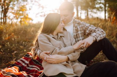 Sonbahar ormanında eğlenen iki güzel insan. Sevimli bir kadın ve erkek güneşli bir parkta yürüyor, sarılıyorlar. Dışarıda bir randevuda. Aşk kavramı, rahatlama..