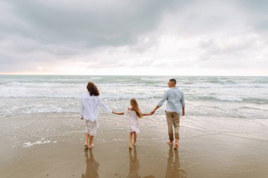 Genç bir aile, bebeğin deniz kıyısında birlikte vakit geçirmesini bekliyor. Hamile karısı ve kızı olan güzel bir koca. Yürüyor ve eğleniyor. Birlikte dışarıda vakit geçiriyorlar. Doğa ve çocukluk kavramı.