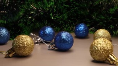 Geleneksel Noel süsleri. Noel altın ve mavi topları, gri arka planda izole edilmiş çelenkleri olan mücevherler..