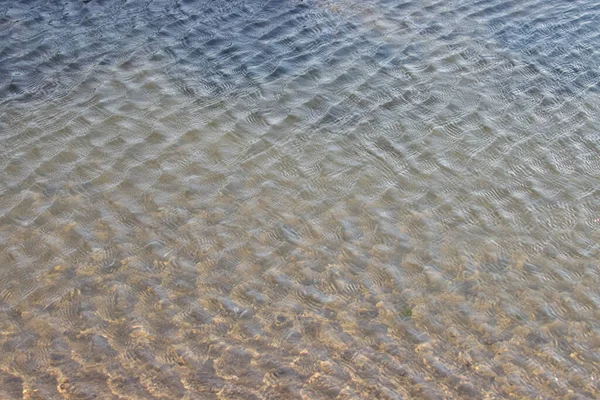 Ripple ocean water over beach sand. Water surface.