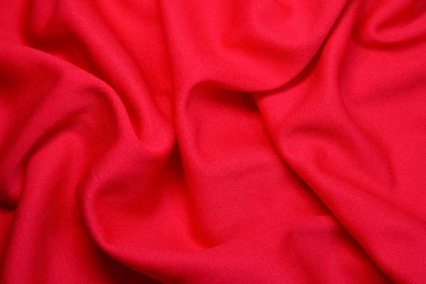 Red fabric background. Red cloth waves background texture. Red fabric cloth textile material.