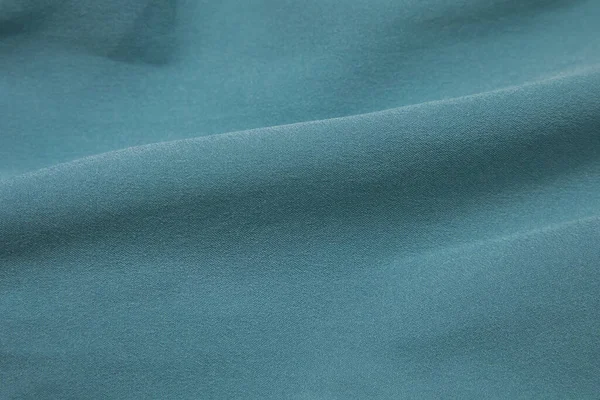 Turquoise fabric background. Turquoise cloth waves background texture. Turquoise fabric cloth textile material.