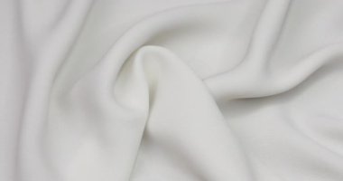 White fabric background. White cloth waves background texture. White fabric cloth textile material.