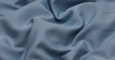 Blue fabric background. Blue cloth waves background texture. Blue fabric cloth textile material.