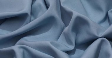 Blue fabric background. Blue cloth waves background texture. Blue fabric cloth textile material.