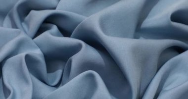 Blue fabric background. Blue cloth waves background texture. Blue fabric cloth textile material.
