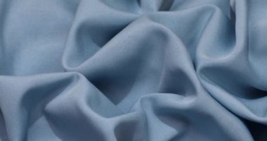 Blue fabric background. Blue cloth waves background texture. Blue fabric cloth textile material.