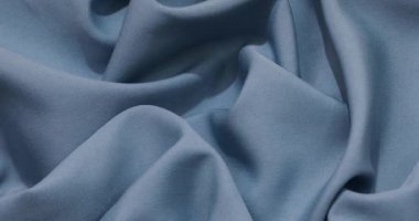 Blue fabric background. Blue cloth waves background texture. Blue fabric cloth textile material.