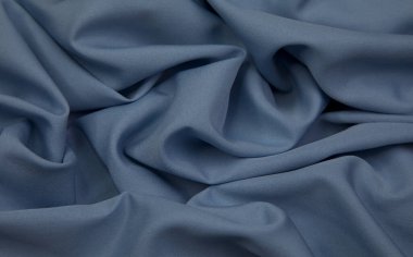 Blue fabric background. Blue cloth waves background texture. Blue fabric cloth textile material.