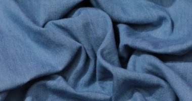 Mavi kot kumaş arka plan. Mavi kot kumaş arka plan dokusunu dalgalandırıyor. Mavi kot kumaş kumaş kumaş kumaş..