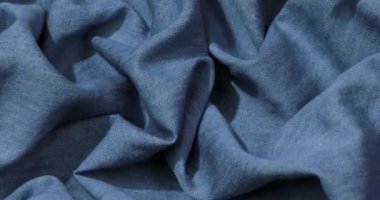 Mavi kot kumaş arka plan. Mavi kot kumaş arka plan dokusunu dalgalandırıyor. Mavi kot kumaş kumaş kumaş kumaş..