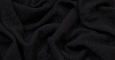 Black fabric background. Black cloth waves background texture. Black fabric cloth textile material.