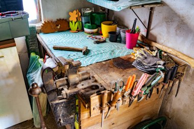 Çeşitli araçlar: dosya, tornavida, çekiç, pense, bahçe aletleri köy garajı veya manufactory 'daki ahşap rafta sergileniyor, kırsal bir bahçe evindeki atölye atölyesi. Hobi, kiralık etkinlik