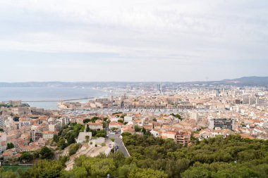 Marsilya 'nın güzel hava manzarası, bulutlu bir gökyüzünün altında kıyı şeridini ve tarihi yapıları gösteriyor..