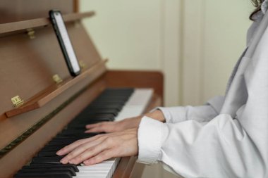 Piyano çalan ellerin yakın çekimi, kendini adama, müziğe olan tutku, yaratıcılık ve sanatsal beceri