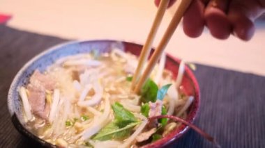 Yakın plan. Lezzetli Asya eriştesi yiyen birinin fotoğrafı.