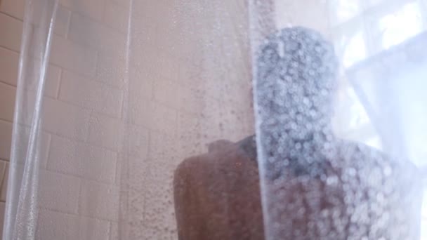ぼやけたガラスの背後にある女性 準備中の女の子は シャワーを浴びる 浴室で女性 — ストック動画