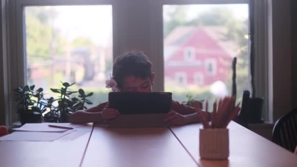 소년은 책상에서 디지털 태블릿 컴퓨터를 사용하고 있습니다 — 비디오