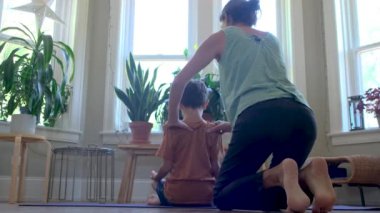 Genç anne çocuklara yoga öğretiyor. Evde yoga, asanas, sağlıklı yaşam tarzı, dengeli farkındalık eğitimi. Kavramları...