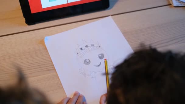 机でタブレットコンピュータを使って漫画キャラクターを描く少年 — ストック動画