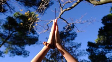  Taoist Budist tütsülü kadın eli, doğal çevre kavramında güneş ışınları ile tespih, huzur, sükunet, farkındalık yoga, meditasyon.