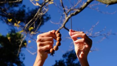 Taoist Budist tütsülü kadın eli, doğal çevre kavramında güneş ışınları ile tespih, huzur, sükunet, farkındalık yoga, meditasyon.