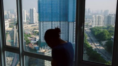 Pencerenin yanındaki üzgün kadının silueti