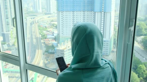 Fiatal Arab Muszlim Fejkendős Hidzsáb Használ Okos Telefon Otthon Ablak — Stock videók