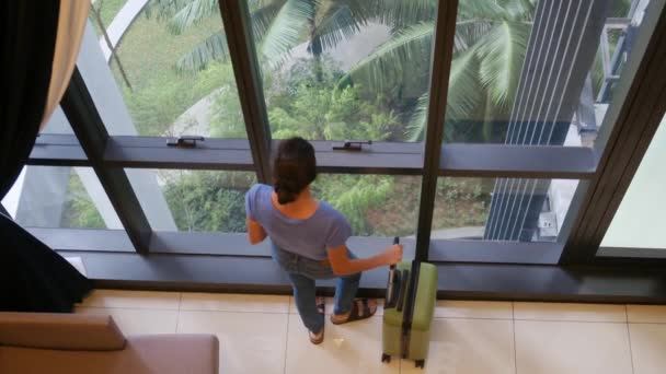 スーツケース付きの窓の近くに立っている観光女性のトップビュー — ストック動画