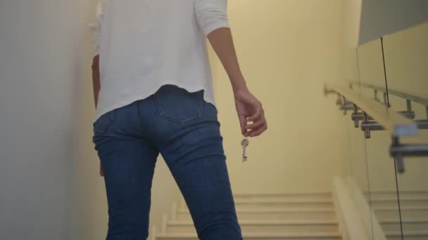 階段に新しい家のキーを握る焦点の女性の手を閉めて下さい — ストック動画