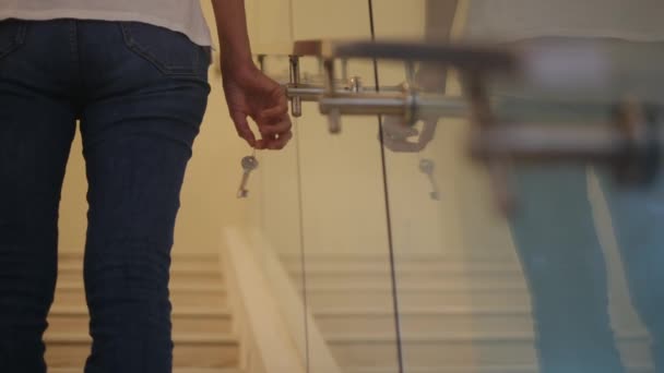 階段に新しい家のキーを握る焦点の女性の手を閉めて下さい — ストック動画
