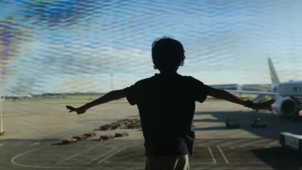 在机场玩乐的男孩 背景是飞机 — 图库视频影像