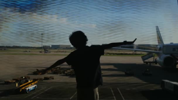 在机场玩乐的男孩 背景是飞机 — 图库视频影像