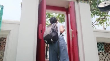 Sırt çantalı kadın gezginin arkasında Güneydoğu Asya 'daki Budist kültürünün cazibe mimari geçidinde yürüyor.