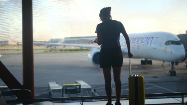 Mujer Viajera Espera Con Maleta Junto Ventana Del Aeropuerto Mirando — Vídeos de Stock