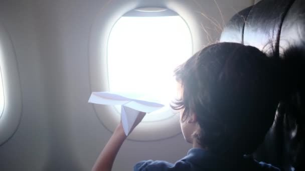 有纸飞机窗玻璃的小男孩 — 图库视频影像