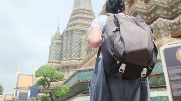 在背负背包的女旅行家身后 行走在东南亚佛教文化的吸引人的建筑塔中 — 图库视频影像