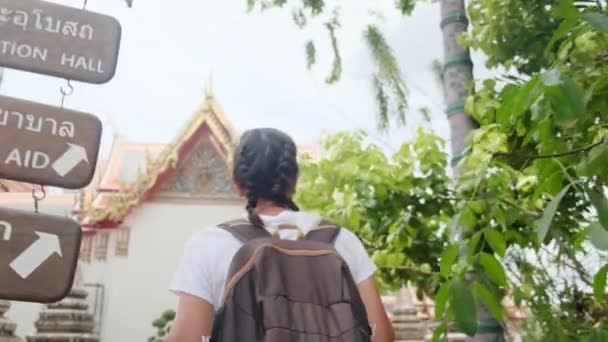 東南アジアの仏教文化のアトラクション建築パゴダを歩くバックパック旅行の背後にある女性旅行者 — ストック動画