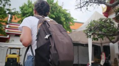 Sırt çantalı kadın gezginin arkasında Güneydoğu Asya 'daki Budist kültürünün cazibe mimari geçidinde yürüyor.