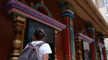 Sırt çantalı kadın gezginin arkasında Güneydoğu Asya 'daki Budist kültürünün cazibe mimari geçidinde yürüyor.