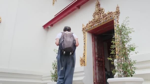 在背负背包的女旅行家身后 行走在东南亚佛教文化的吸引人的建筑塔中 — 图库视频影像